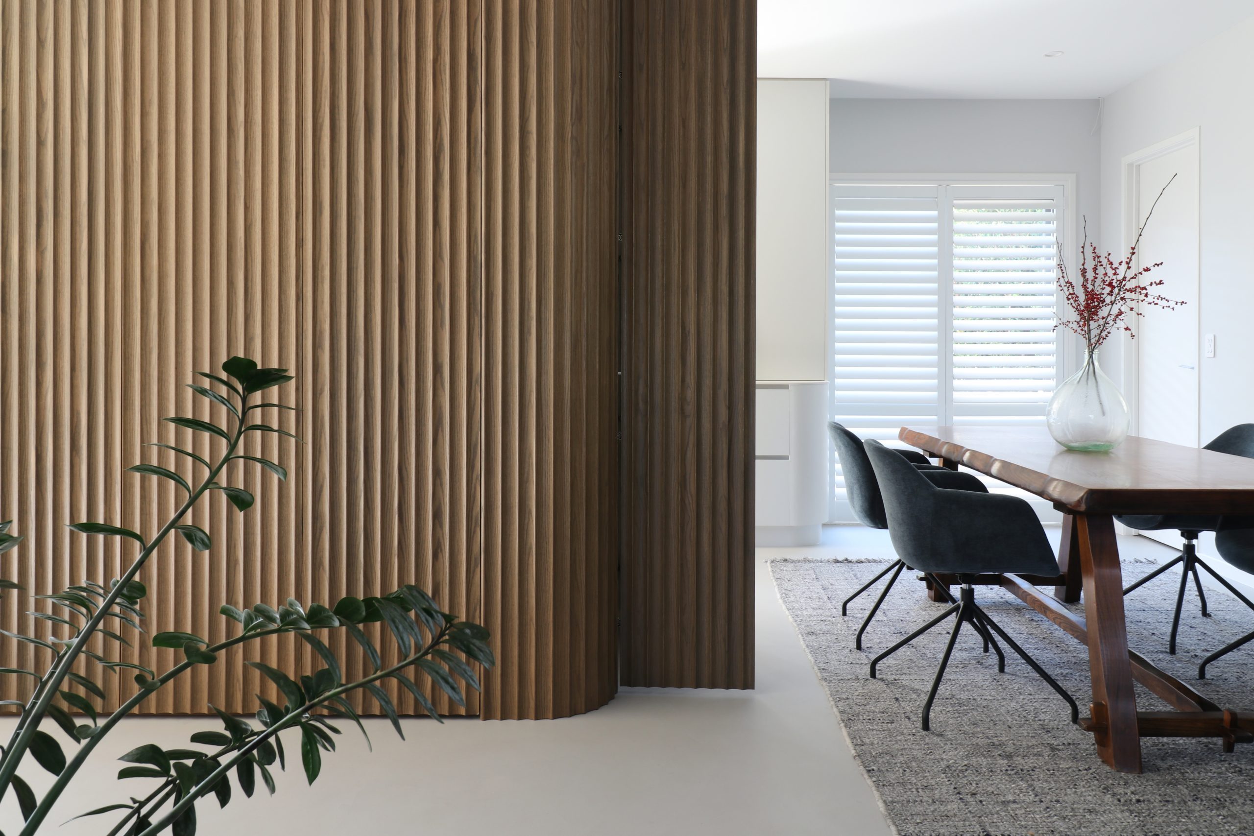 Tall kitchen unit in Ripple Flex oak featuring a concealed door at the end, part of a seamless custom cabinetry design in the Bayswater kitchen by Fluid Interiors.
