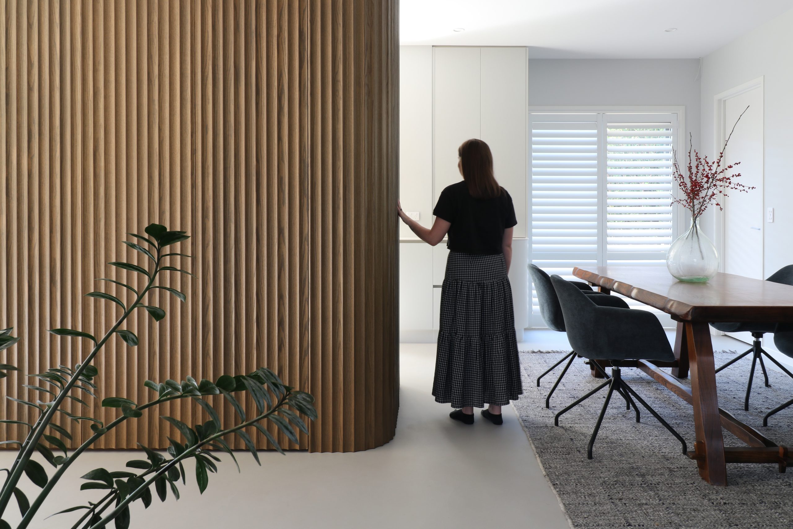 Tall kitchen unit in Ripple Flex oak featuring a concealed door at the end, part of a seamless custom cabinetry design in the Bayswater kitchen by Fluid Interiors.