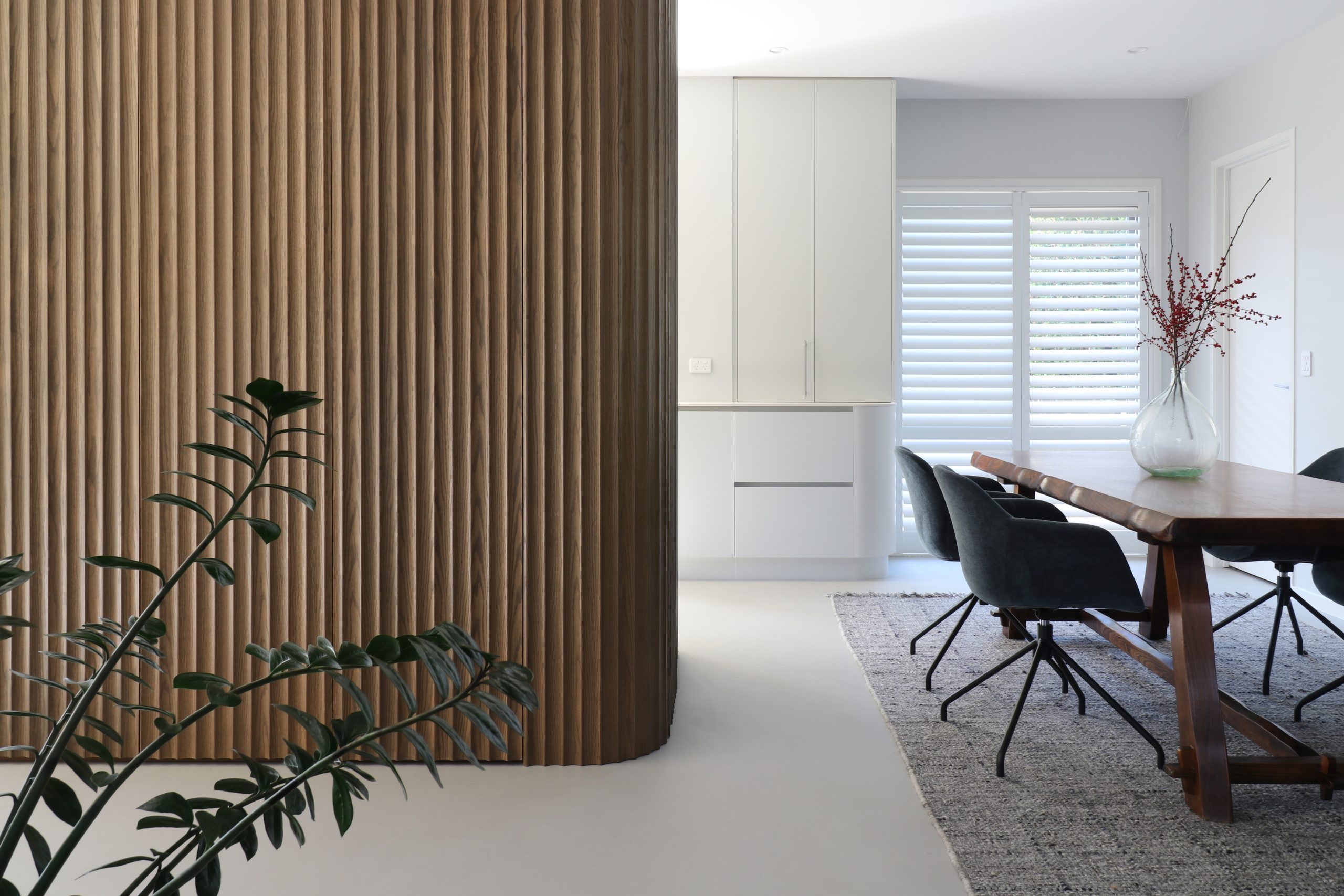 Tall kitchen unit in Ripple Flex oak featuring a concealed door at the end, part of a seamless custom cabinetry design in the Bayswater kitchen by Fluid Interiors.