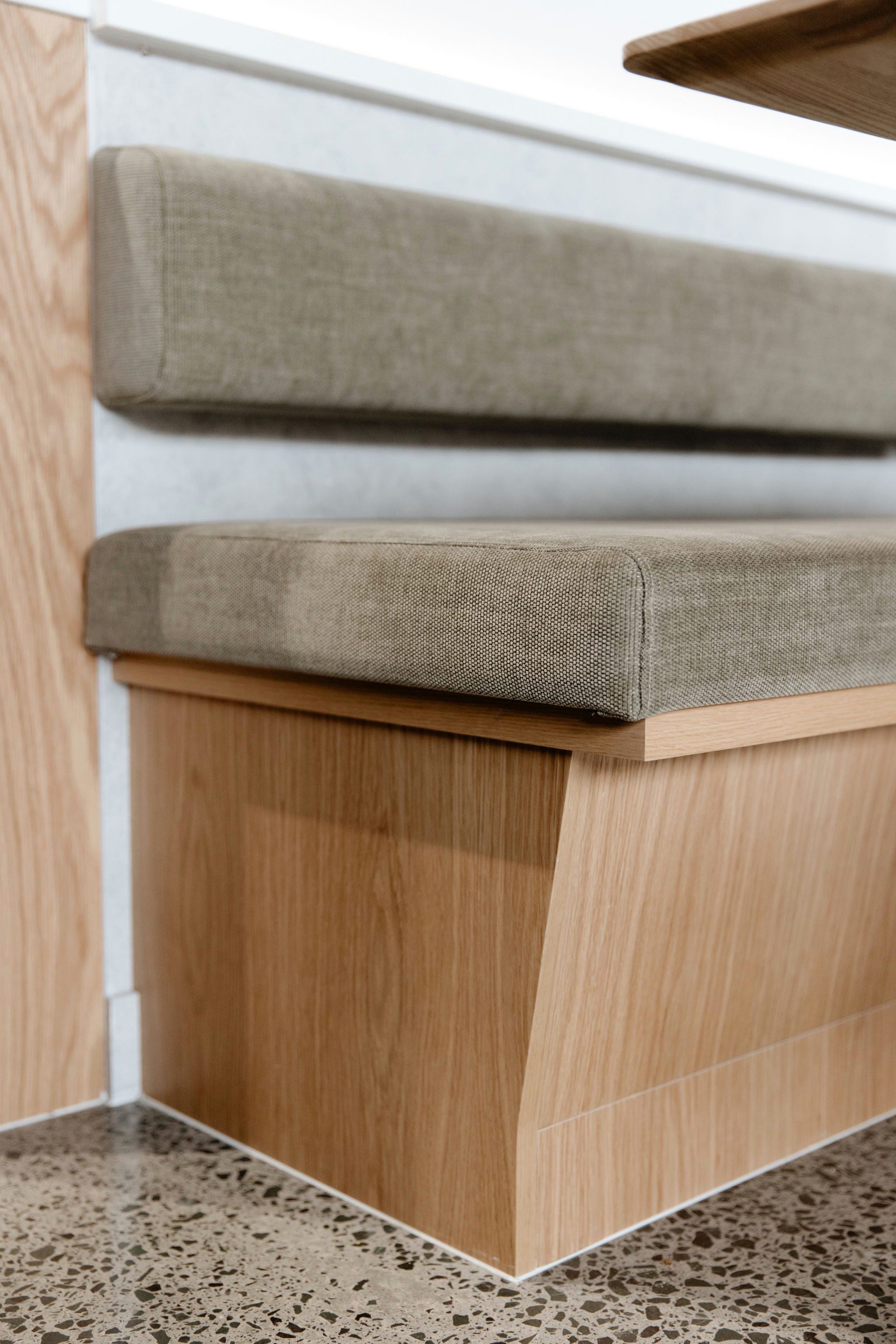 Close-up of oak veneer seat detail with hidden storage at Kinfolk Café