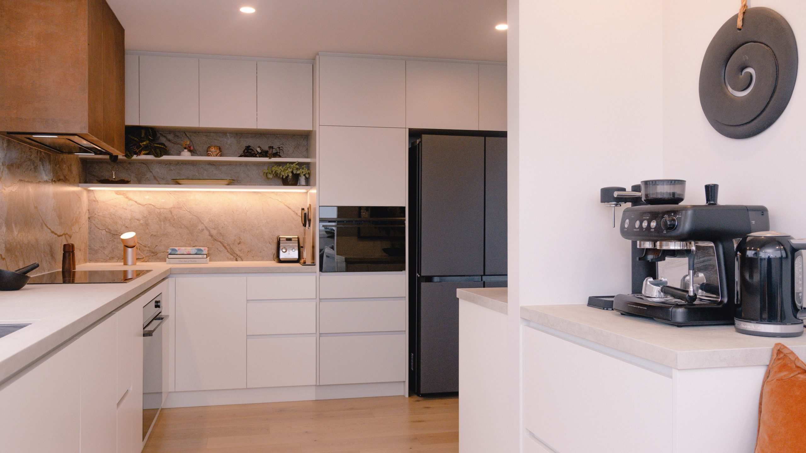 Coastal modern kitchen with Laminex cabinetry and Dekton benchtops, overlooking Rangitoto.