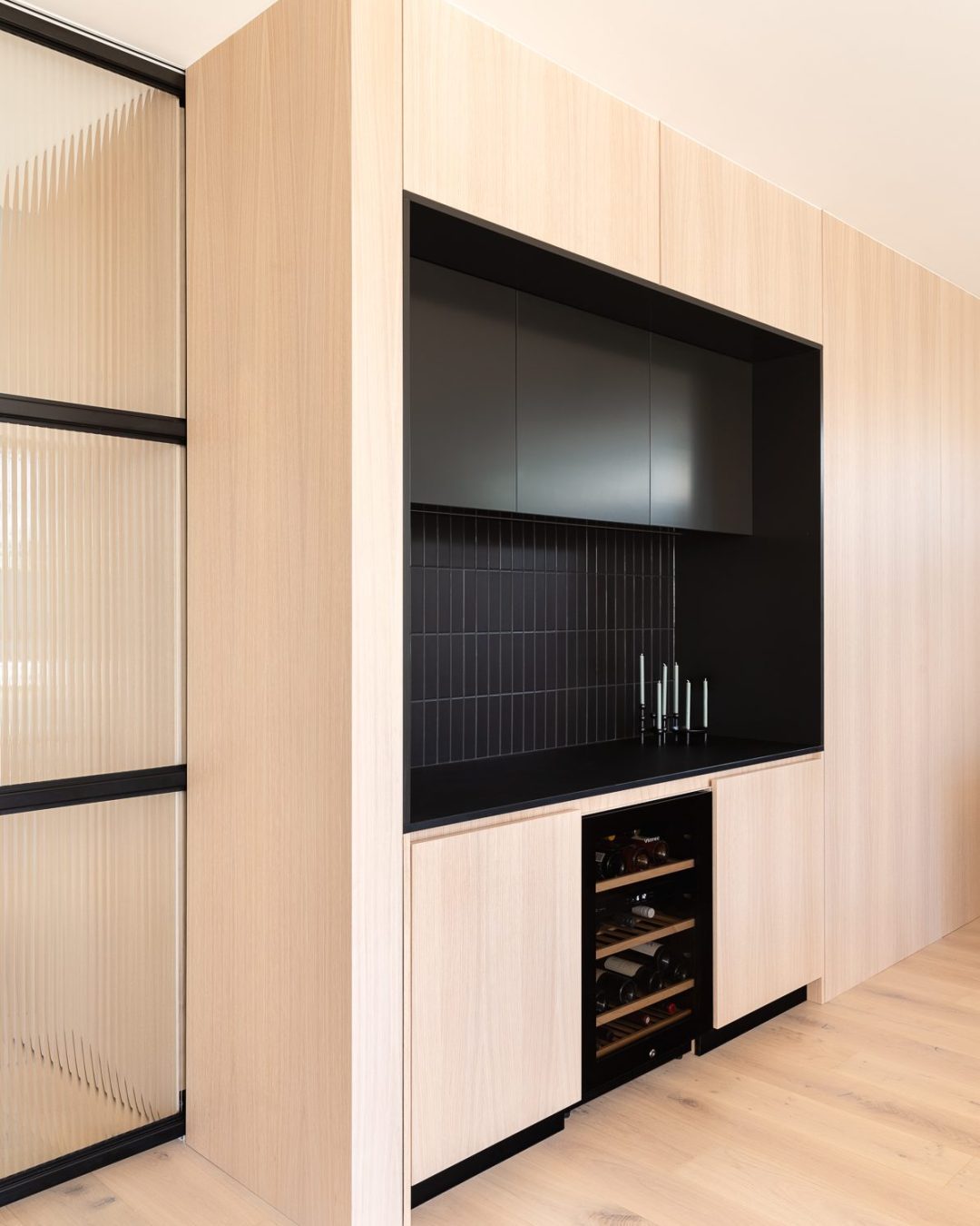 Bar area integrated into American oak veneer feature wall in Mt Eden home, detailed, manufactured, and installed by Fluid Interiors.