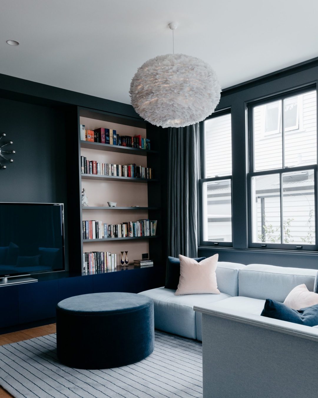 Custom lounge cabinetry by Fluid Interiors installed against a dark green feature wall in Herne Bay home.