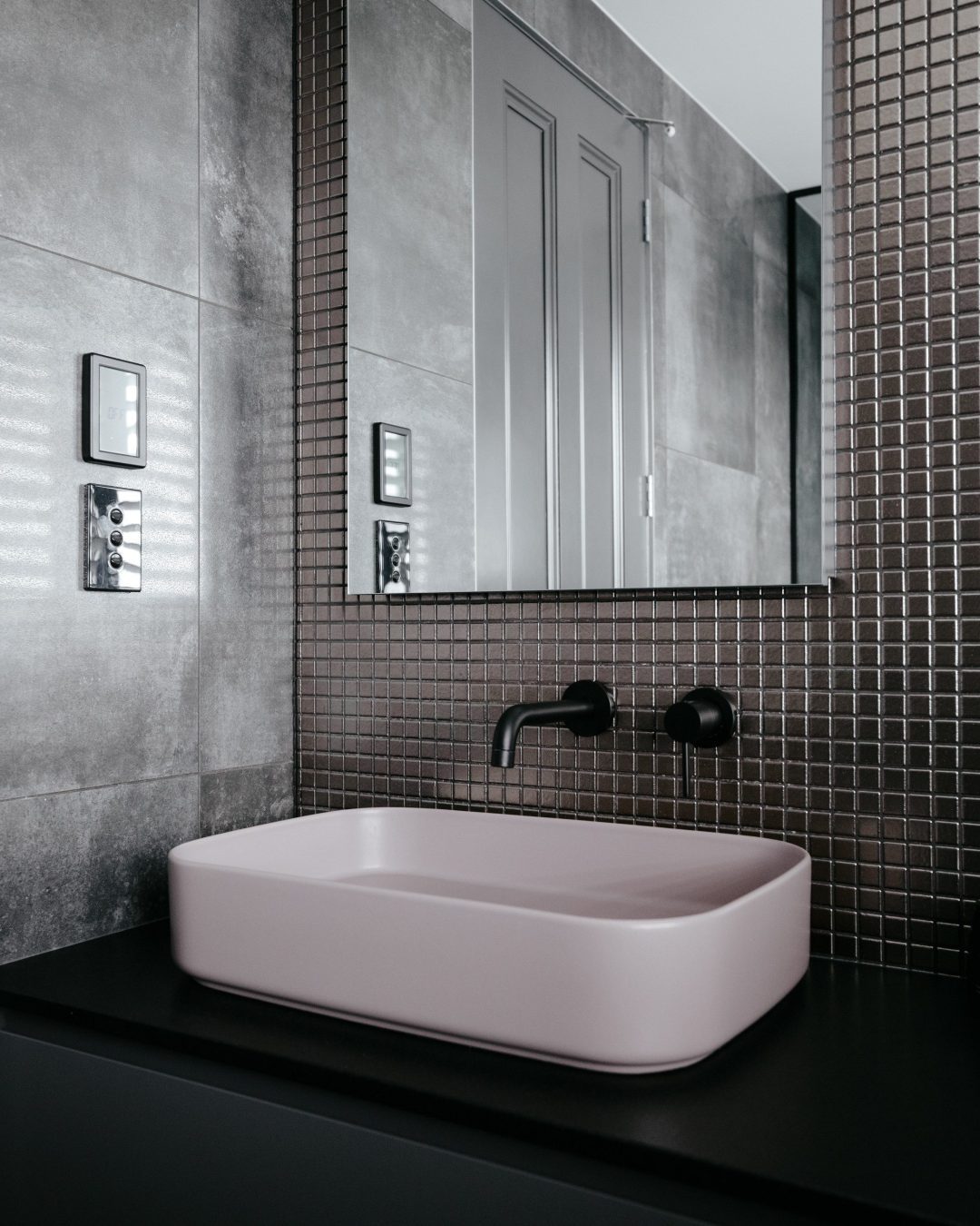 Close-up of custom pink basin on black vanity with black benchtop in Herne Bay bathroom by Fluid Interiors.