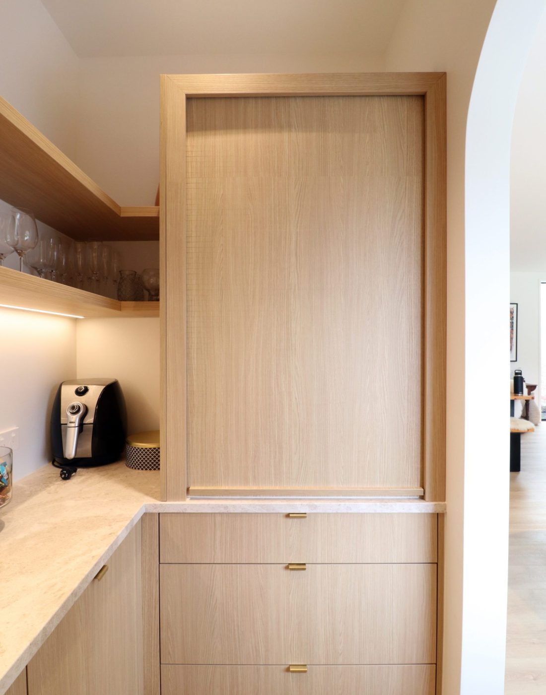 Interior view of walk-in pantry in Wainui kitchen by Fluid Interiors, featuring appliance garage with Sage roller door, floating shelves, and bench space.